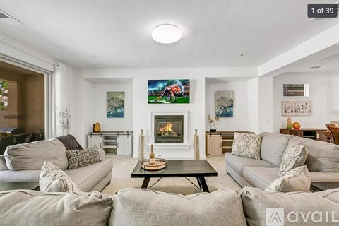 A living room with a fireplace and a painting on the wall.
