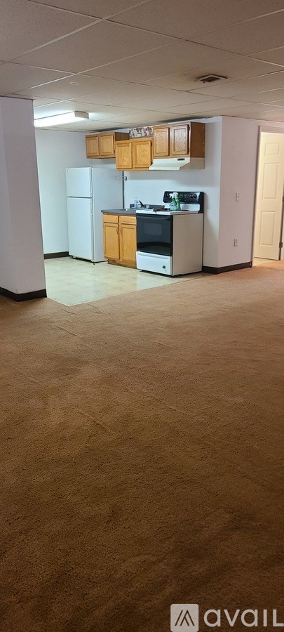 A kitchen with white appliances and wooden cabinets.