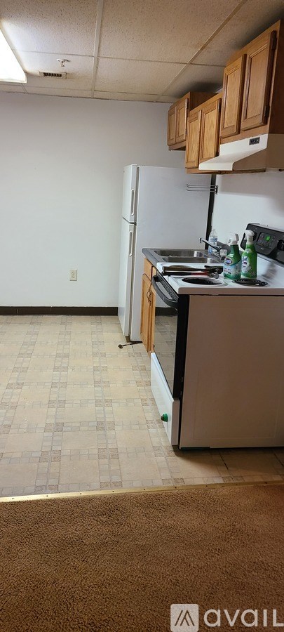 A kitchen with a refrigerator, microwave, and oven.