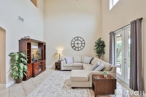 A living room with a white couch and a wooden entertainment center.