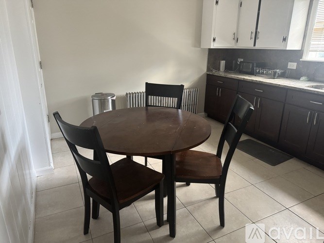 A brown wooden table with two chairs in a kitchen.