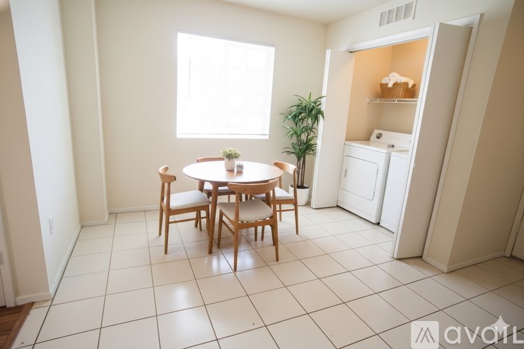 A dining room with a table and chairs.