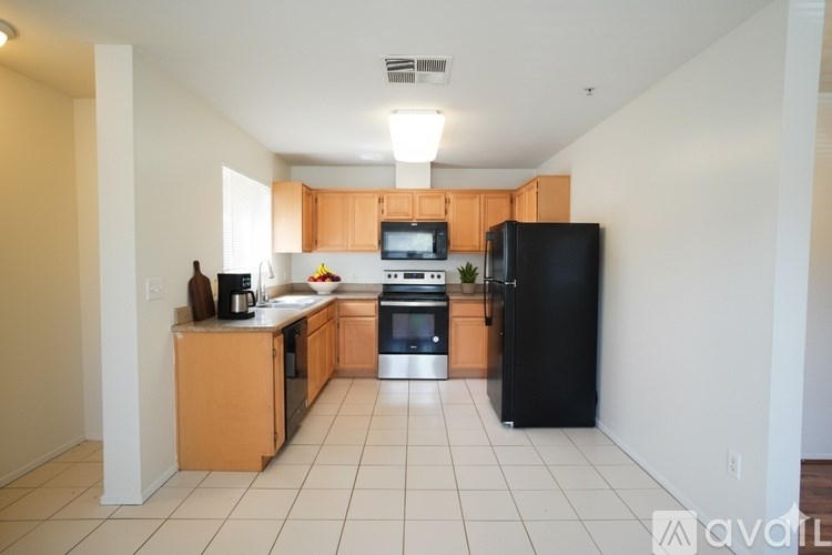 A kitchen with black appliances and wooden cabinets.