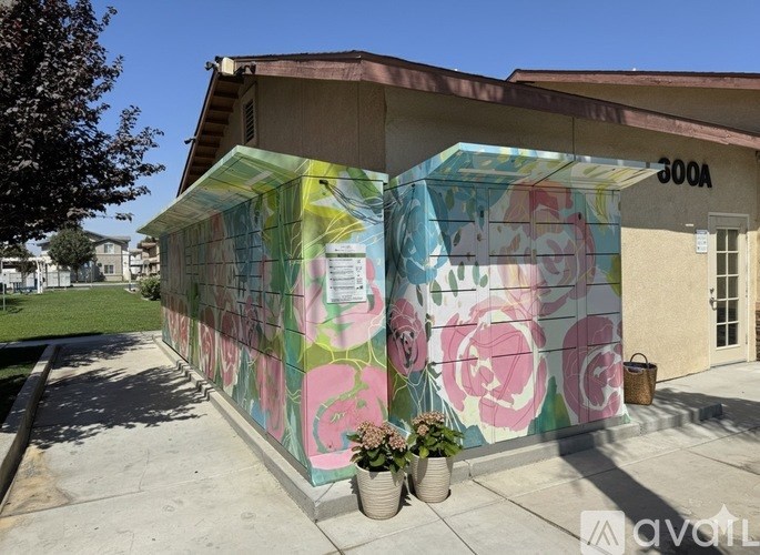 A building with a mural of pink roses painted on its side.