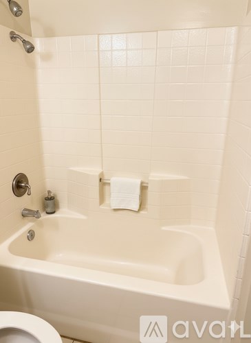 A white bathroom with a tub and toilet.