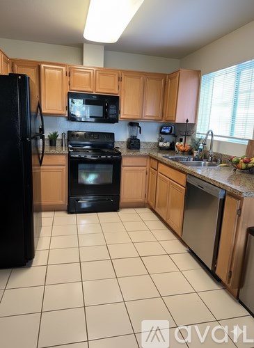 A kitchen with black appliances and wooden cabinets.