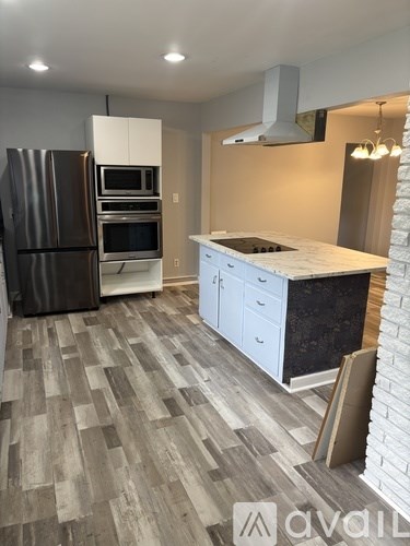 A kitchen with a refrigerator, oven, and microwave.
