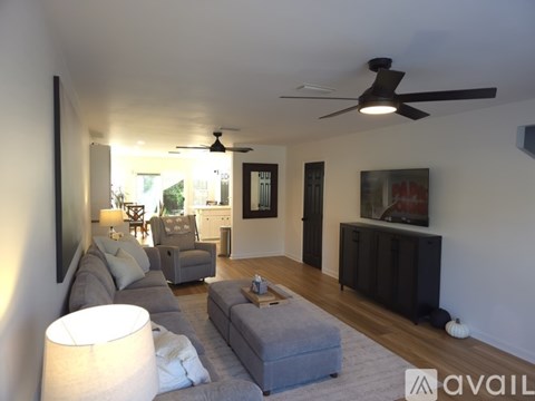 A living room with a grey couch and a white lamp.