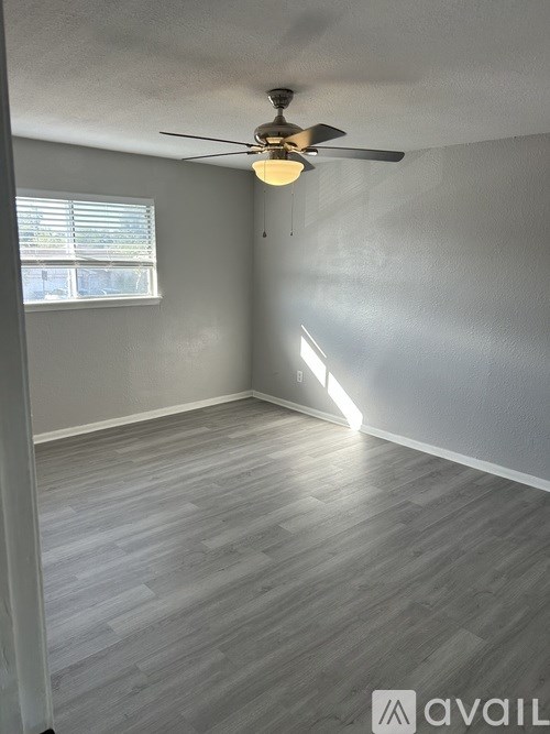 A room with a ceiling fan and a window.