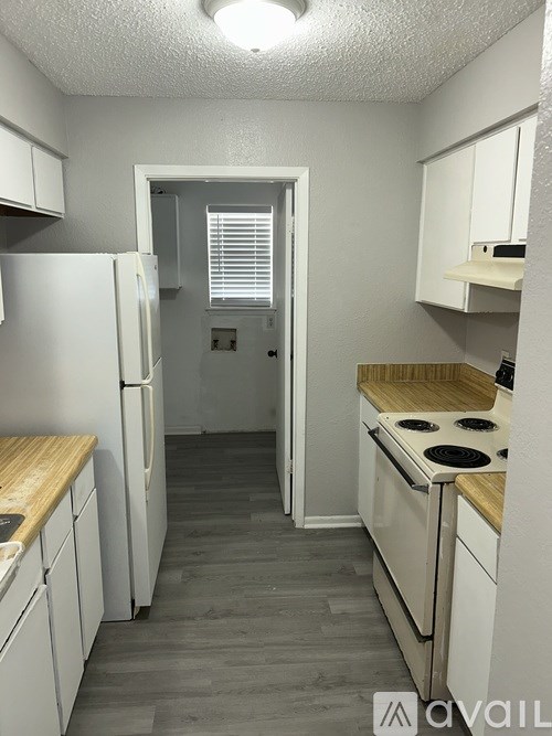 A kitchen with white appliances and wooden countertops.