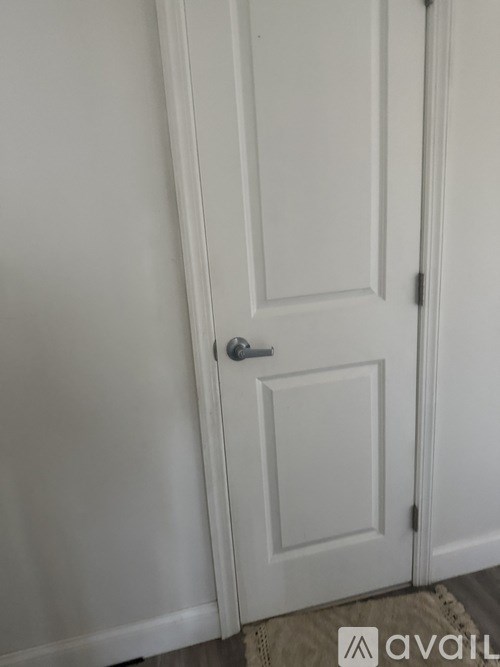 A white door with a silver handle is closed.
