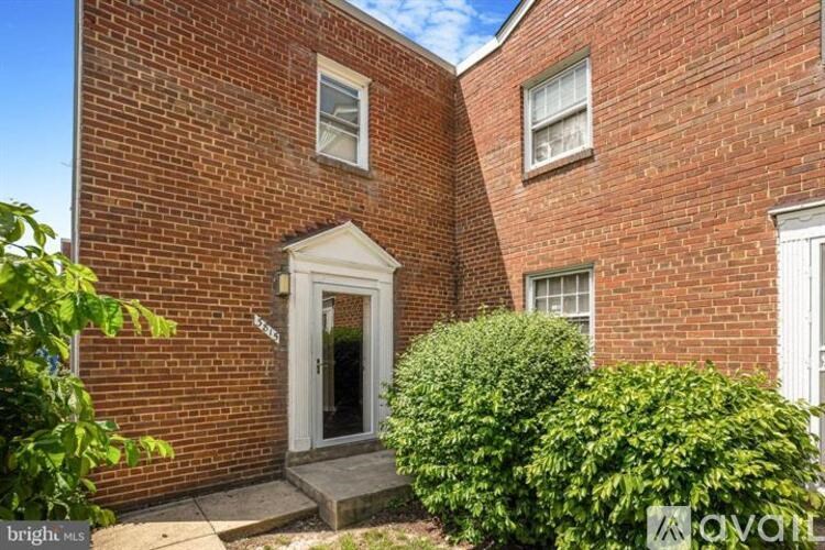 A red brick house with a white door and windows.