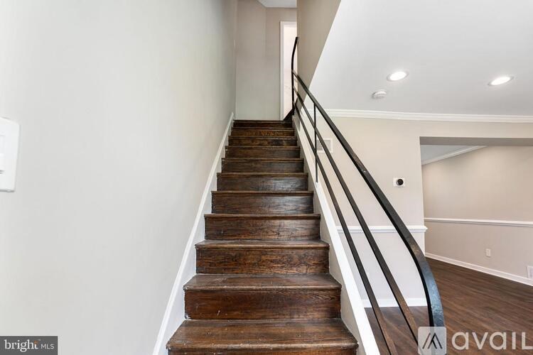 A staircase with a metal railing and wooden steps.