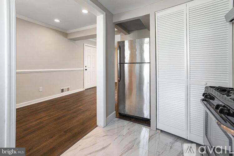 A kitchen with a stainless steel refrigerator and white cabinets.