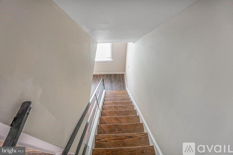 A staircase with wooden steps and a metal railing.