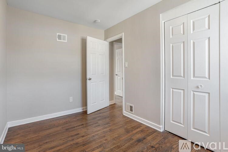 A room with a white door and a wooden floor.