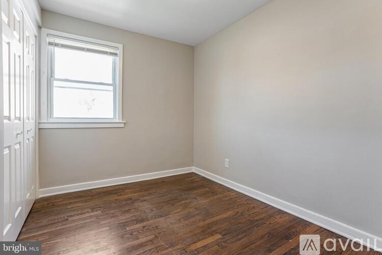 A room with wooden flooring and a window.