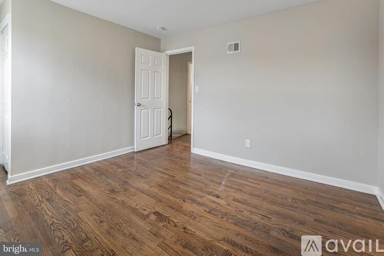 A room with wooden flooring and a white door.