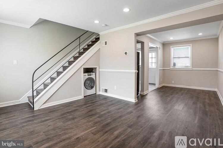 A spacious room with a staircase and a window.