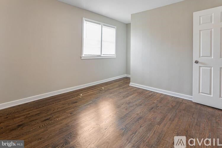 A room with wooden flooring and a white door.