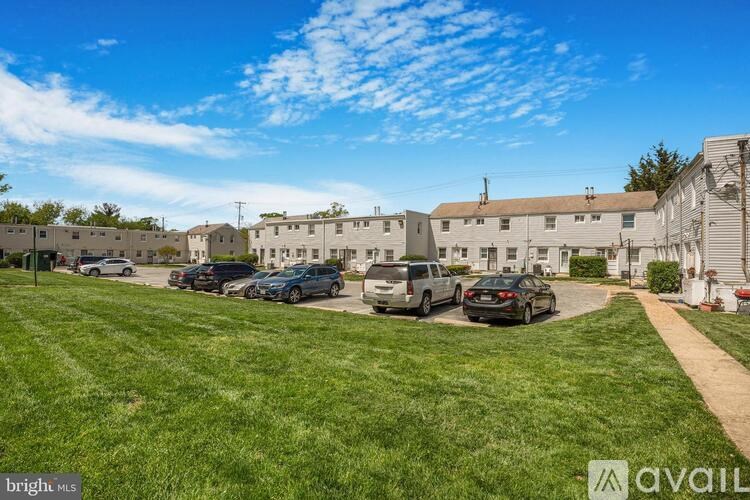 A sunny day in a residential area with houses and parked cars.