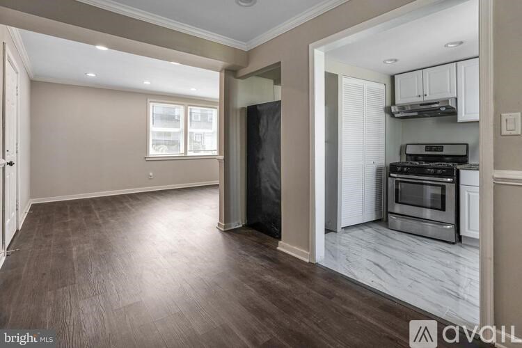 A spacious kitchen with a stainless steel oven and a dark wood floor.