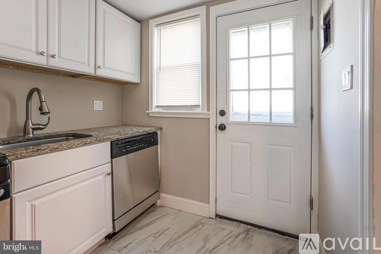 A kitchen with white cabinets and a granite countertop.