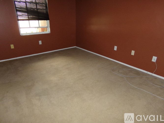 A room with a brown wall and a window with blinds.
