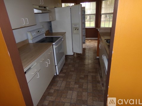 A kitchen with brown floors and white appliances.