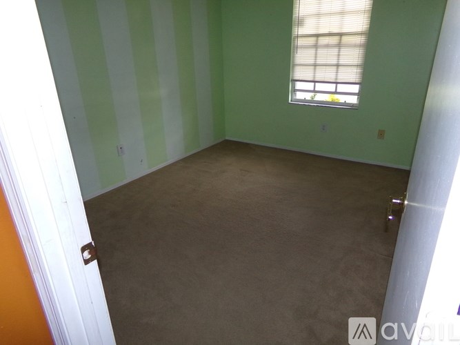A room with green striped walls and a window.