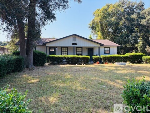 A house with a white fence and a tree in front of it.