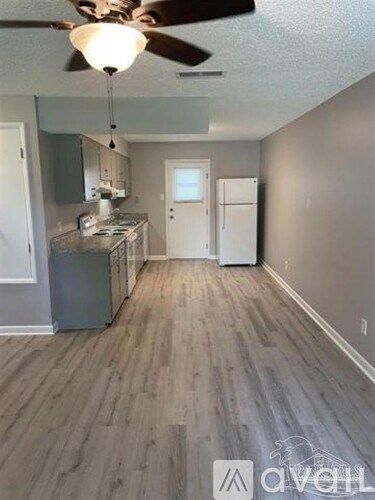 A living room with a kitchen in the background.