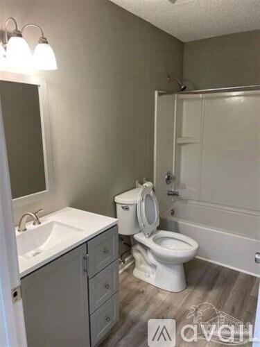 A white toilet sits in a bathroom next to a sink.
