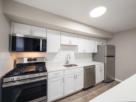 A kitchen with white cabinets and a black oven.