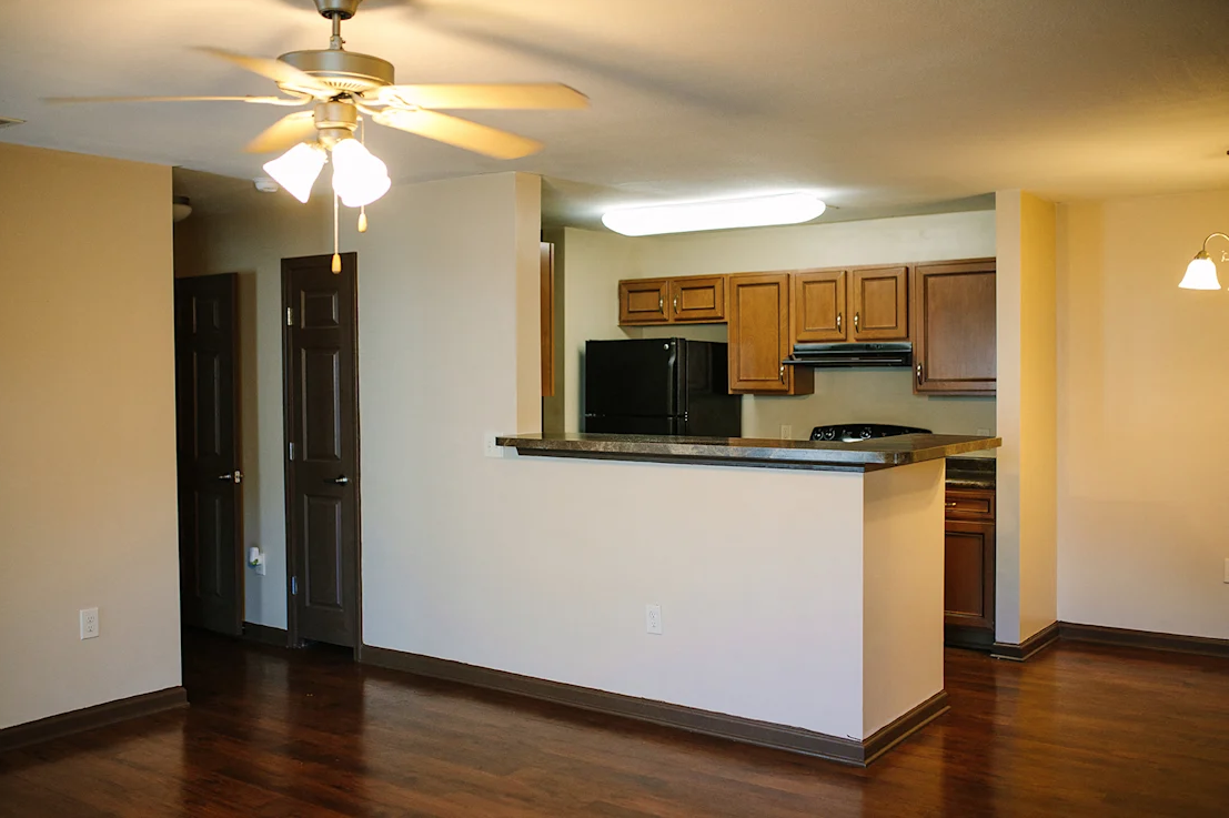 A kitchen with a white counter and a ceiling fan.