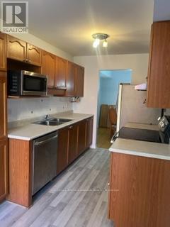 A kitchen with wooden cabinets and a microwave above the stove.