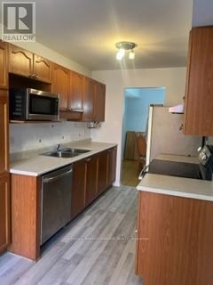 A kitchen with wooden cabinets and a microwave above the stove.