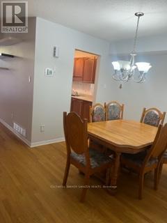 A dining room with a wooden table and chairs.