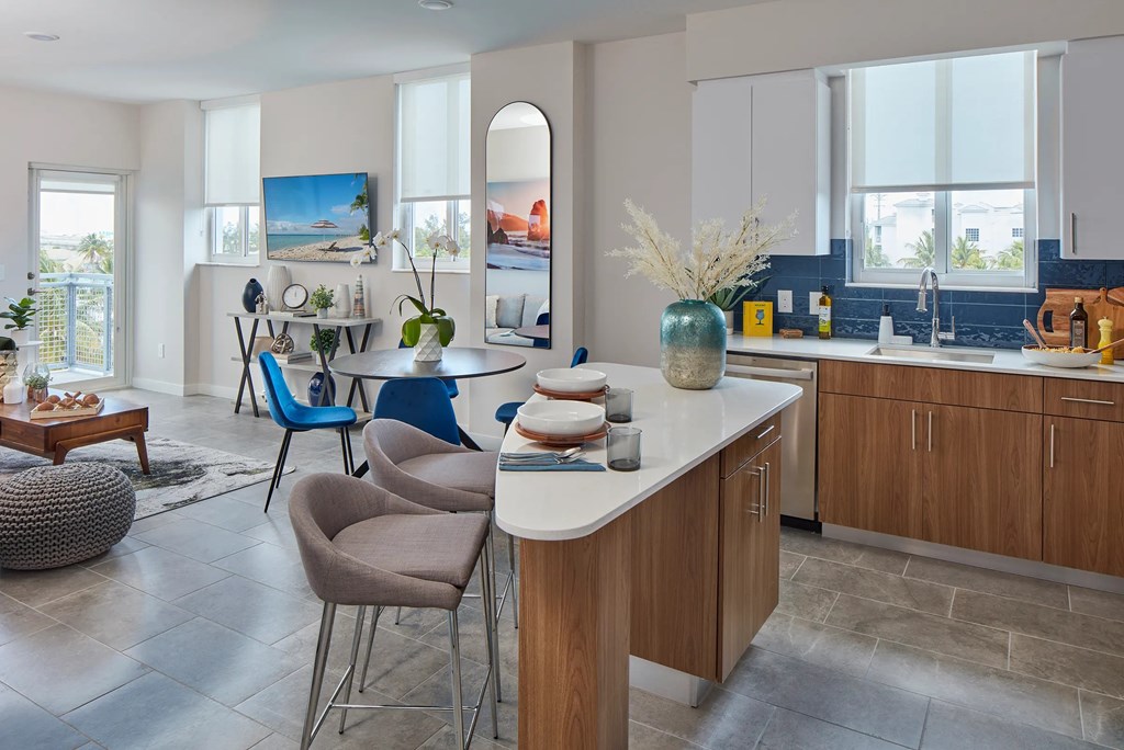 A modern kitchen with a dining area and a living area.