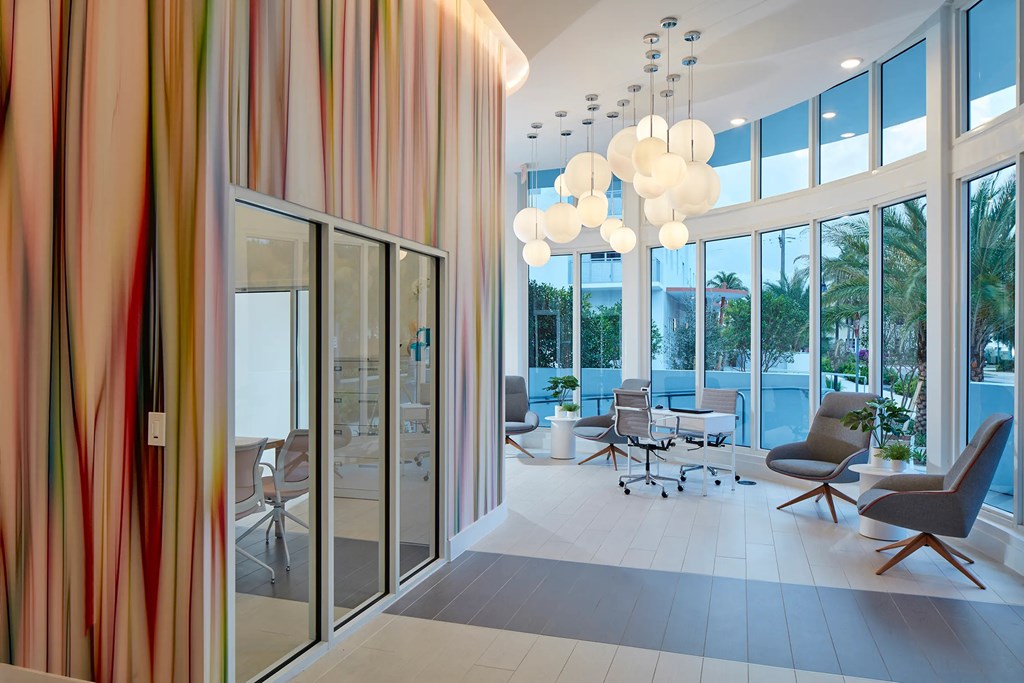A modern office with a glass wall and a striped curtain.