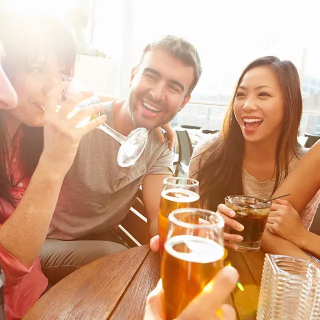 A group of friends enjoying drinks together at a table.