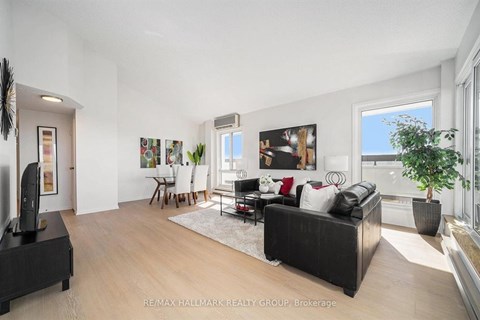 A spacious living room with a black couch and a television.