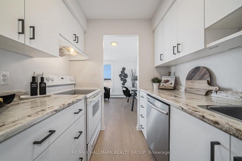 A kitchen with white cabinets and a marble countertop.