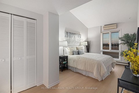 A bedroom with a bed, a desk, and a chair.