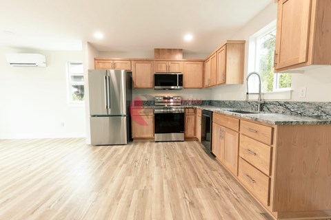 A kitchen with wooden cabinets and a marble countertop.