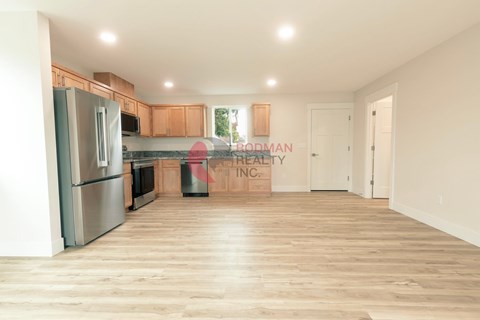 A kitchen with wooden floors and a refrigerator.