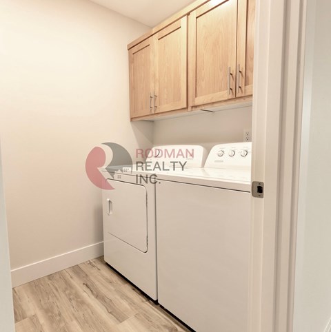A white fridge in a kitchen with wooden cabinets.
