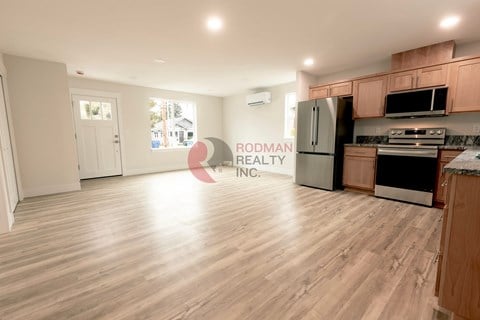 A kitchen with wooden floors and a refrigerator.