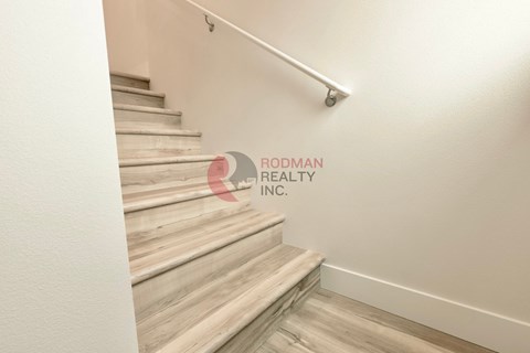 A staircase with a handrail and wooden steps.