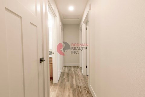 A hallway with a logo of Rodman Realty Inc. on the wall.